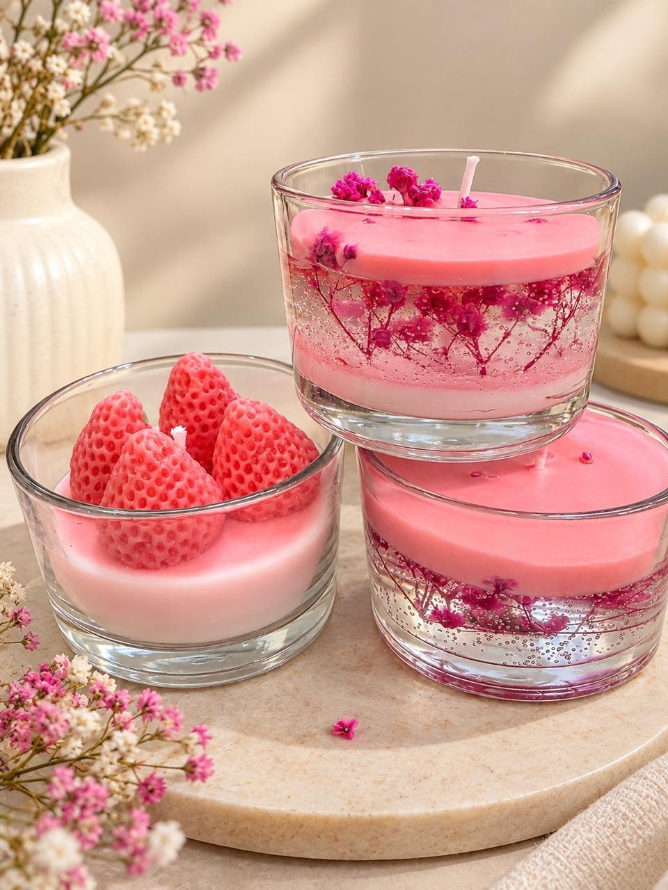 Glass Candle Set: three pink candles in clear glass, one topped with wax strawberries and two with dried pink flowers inside